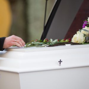 closeup-shot-person-hand-casket-with-blurred-background